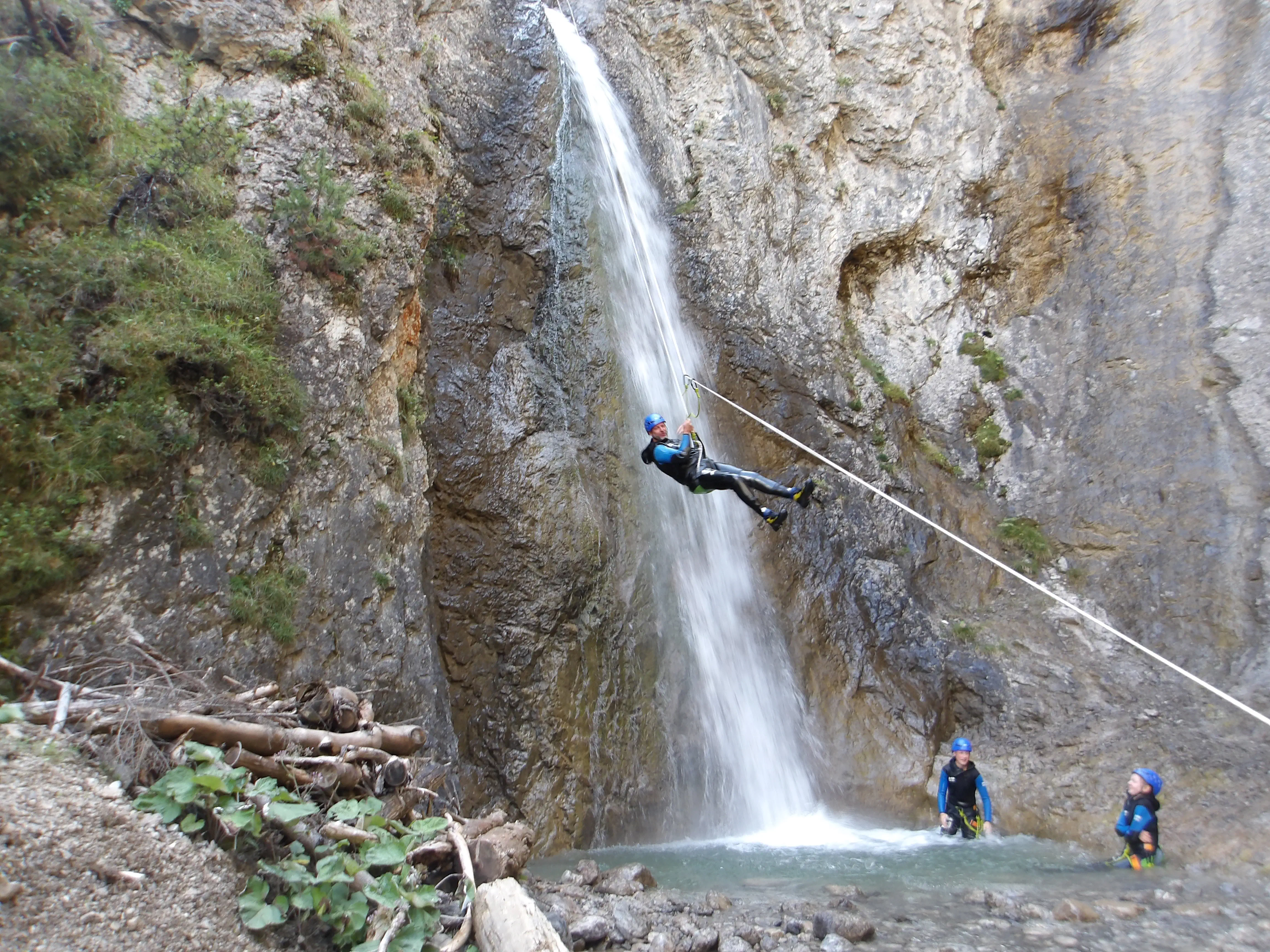 Abseilen mit Seilbahn über Wasserfall.